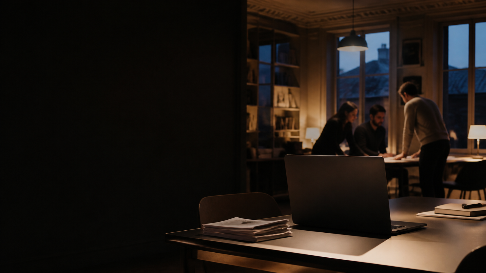 A team working with documents in a quiet evening workspace.